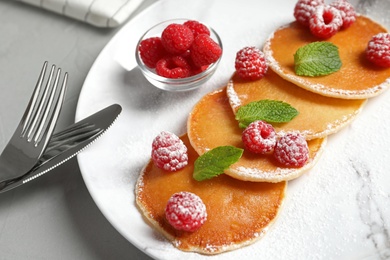 Photo of Tasty pancakes with berries and mint on plate