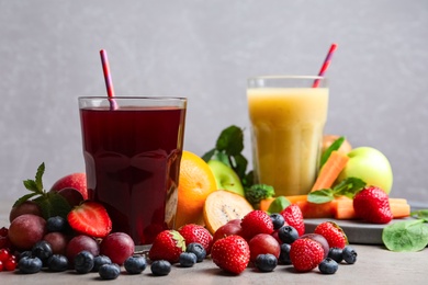 Photo of Delicious juice and fresh ingredients on grey table