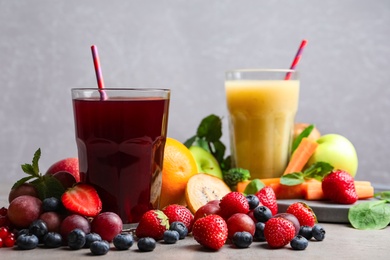 Delicious juice and fresh ingredients on grey table