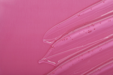 Photo of Pure transparent cosmetic gel on pink background, top view