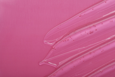 Pure transparent cosmetic gel on pink background, top view