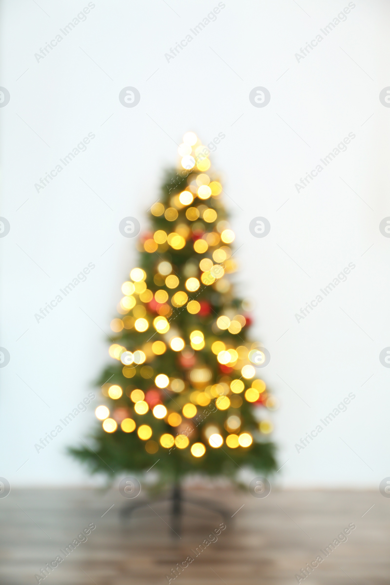 Photo of Blurred view of beautiful Christmas tree with fairy lights, indoors