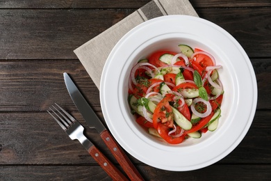 Photo of Plate with delicious fresh salad on table, top view