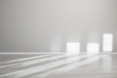 Photo of Light and shadows from window on floor and wall indoors