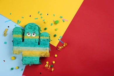 Photo of Cactus shaped pinata and decor on color background, flat lay. Space for text
