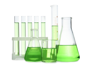 Photo of Different laboratory glassware with light green liquid isolated on white