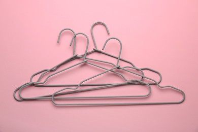 Photo of Many hangers on pink background, top view