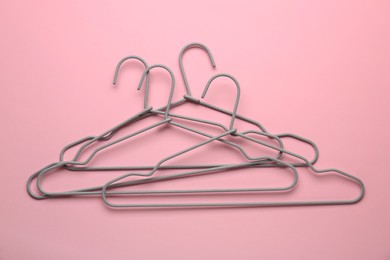 Many hangers on pink background, top view