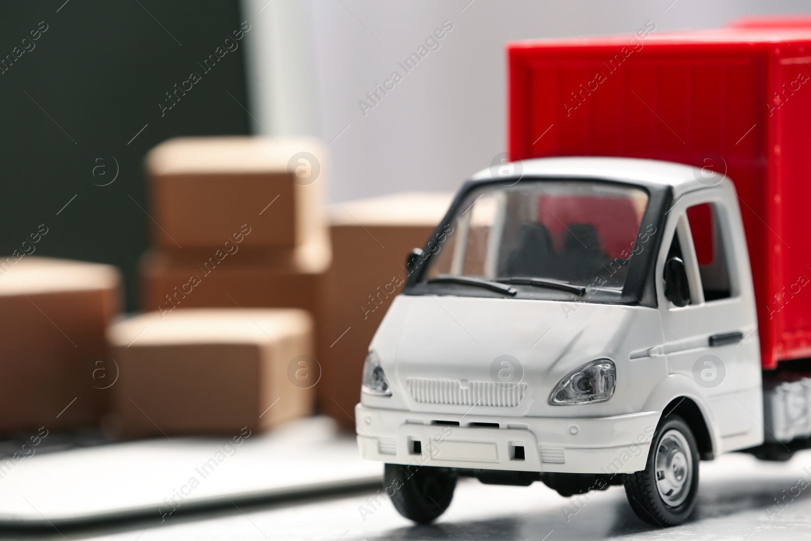 Photo of Toy truck near laptop on table. Logistics and wholesale concept