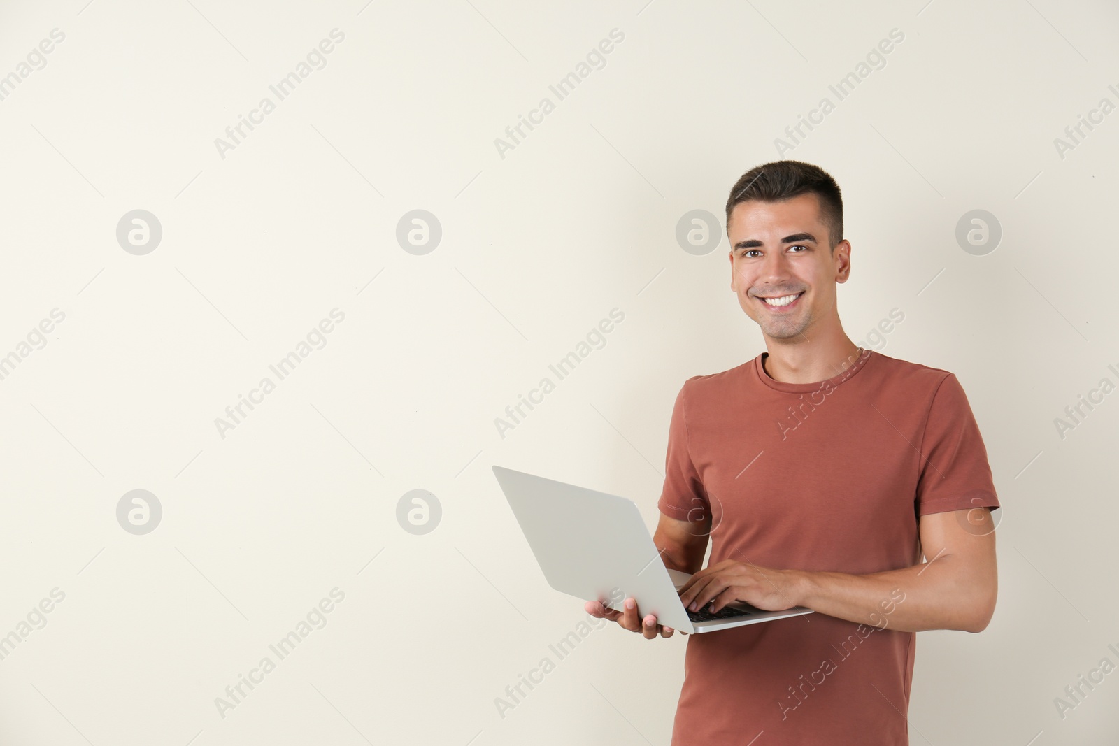 Photo of Man in casual clothes with laptop on color background