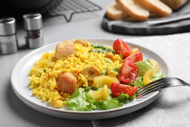 Photo of Delicious pilaf with chicken meat on light grey table