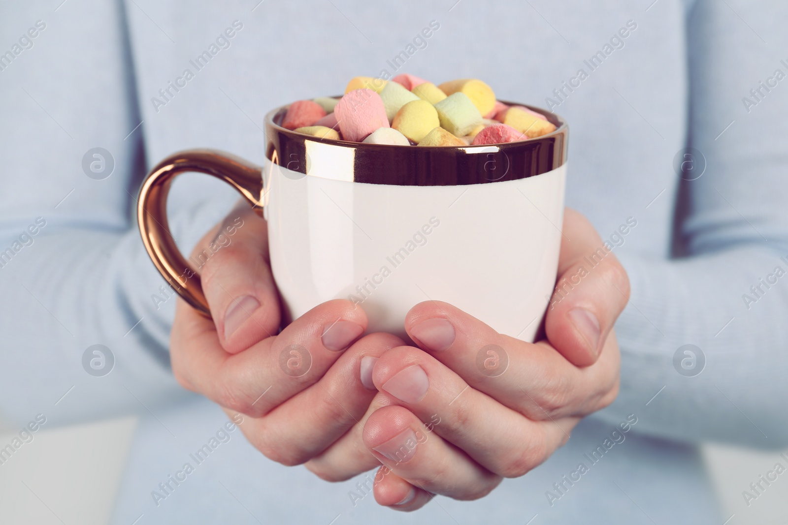 Photo of Woman holding cup of delicious hot chocolate with marshmallows, closeup