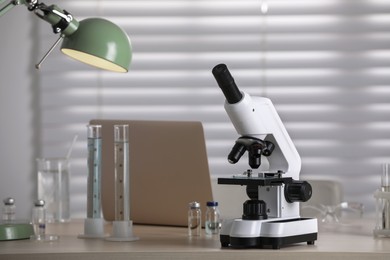Modern medical microscope on wooden table in laboratory