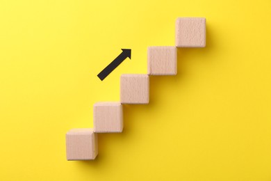 Photo of Business process organization and optimization. Scheme with wooden figures and arrow on yellow background, top view