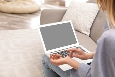 Young woman using video chat on laptop in living room, closeup. Space for design