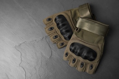 Photo of Tactical gloves on gray background, flat lay with space for text. Military training equipment