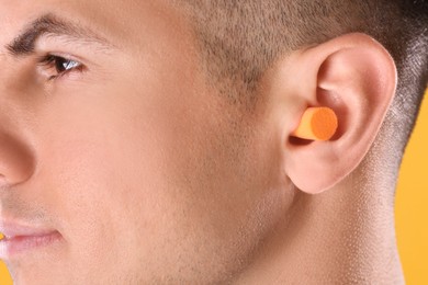 Photo of Man wearing foam ear plug, closeup view