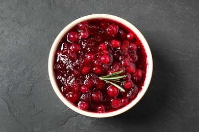 Photo of Cranberry sauce with rosemary on dark grey table, top view