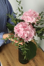 Woman with bouquet of beautiful hortensia flowers indoors, closeup