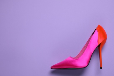 Photo of Beautiful shoe on lilac background, top view/ Space for text