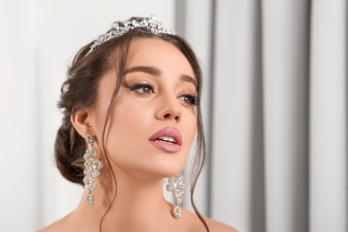 Photo of Beautiful young woman wearing luxurious tiara indoors. Space for text
