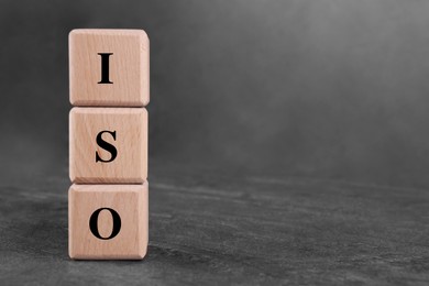 Photo of International Organization for Standardization. Cubes with abbreviation ISO on gray textured table, space for text