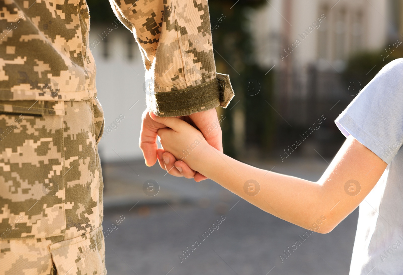 Photo of Father in Ukrainian military uniform and his daughter outdoors, closeup. Family reunion