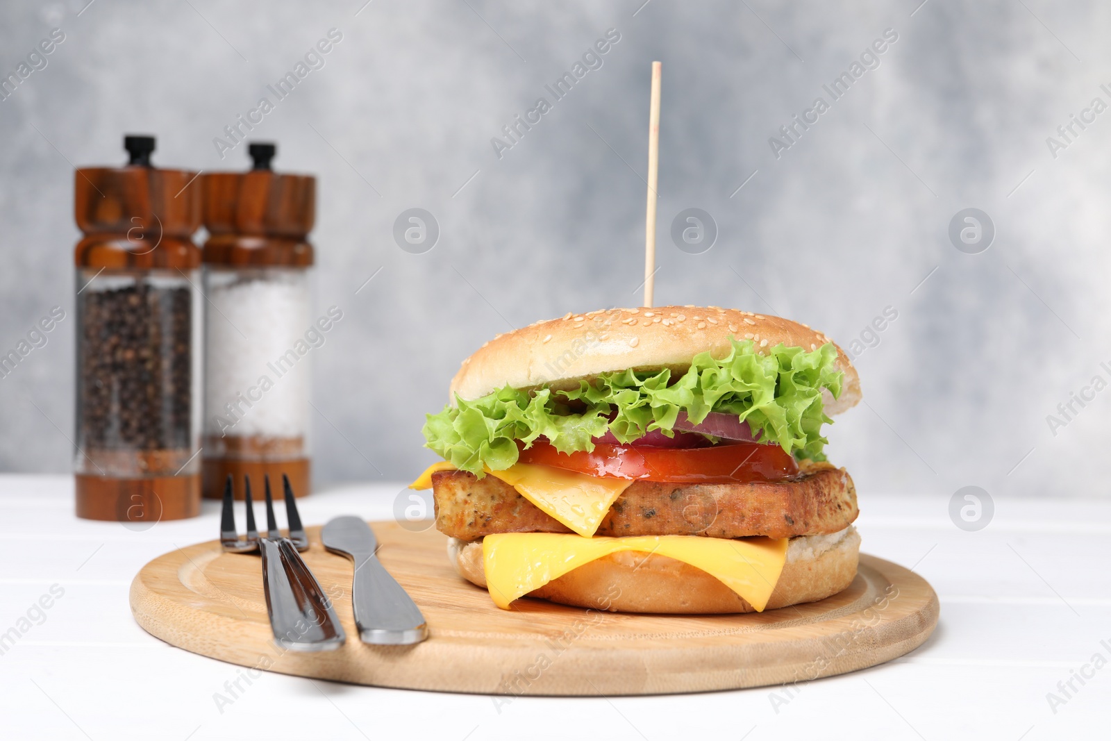 Photo of Delicious burger with tofu and fresh vegetables served on white table