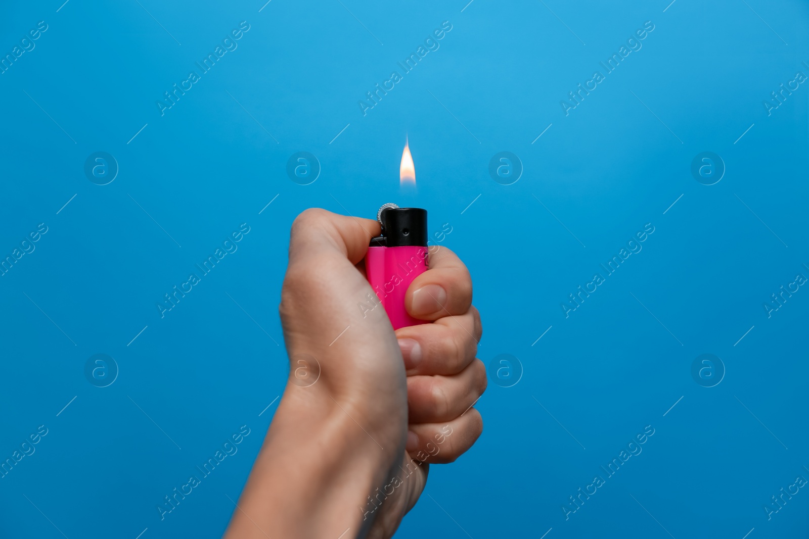 Photo of Woman holding pink lighter on light blue background, closeup