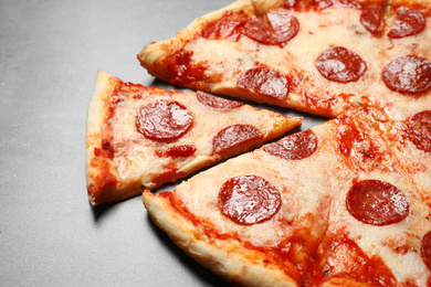 Hot delicious pepperoni pizza on grey table, closeup