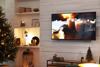 Plasma TV on white wooden wall in living room beautifully decorated for Christmas