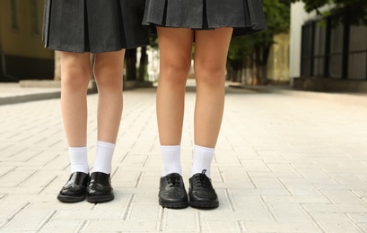 Girls in stylish school uniform outdoors, focus on legs