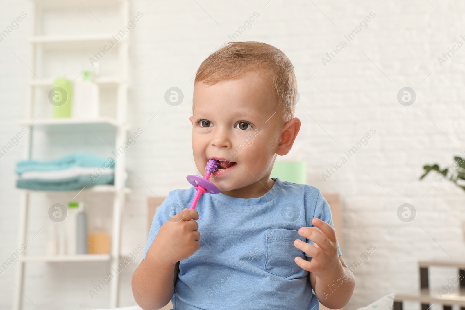 Photo of Cute little boy with toothbrush on blurred background