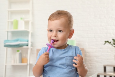 Cute little boy with toothbrush on blurred background