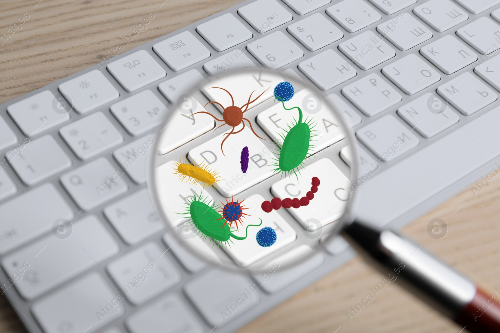 Image of Magnifying glass detecting microbes on keyboard, closeup