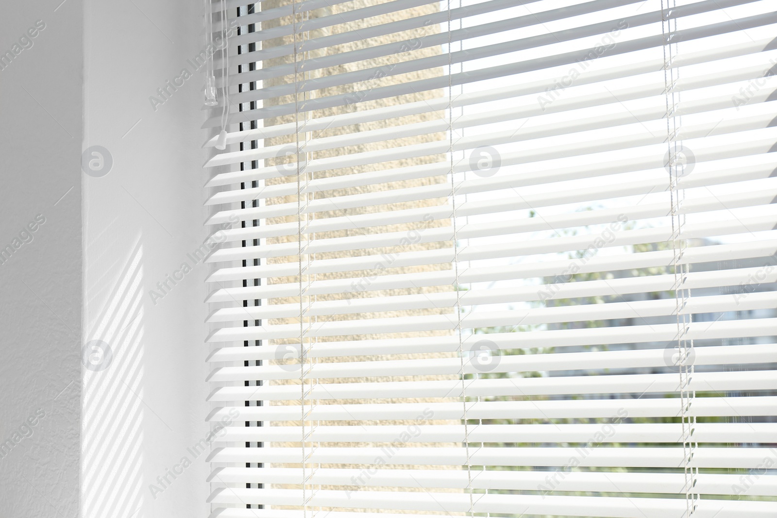 Photo of Window with open modern horizontal blinds indoors, closeup