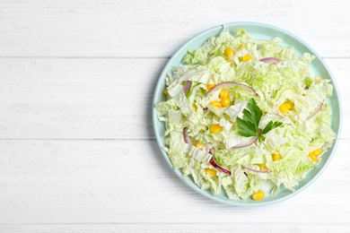 Photo of Fresh napa cabbage salad served on white wooden table, top view. Space for text