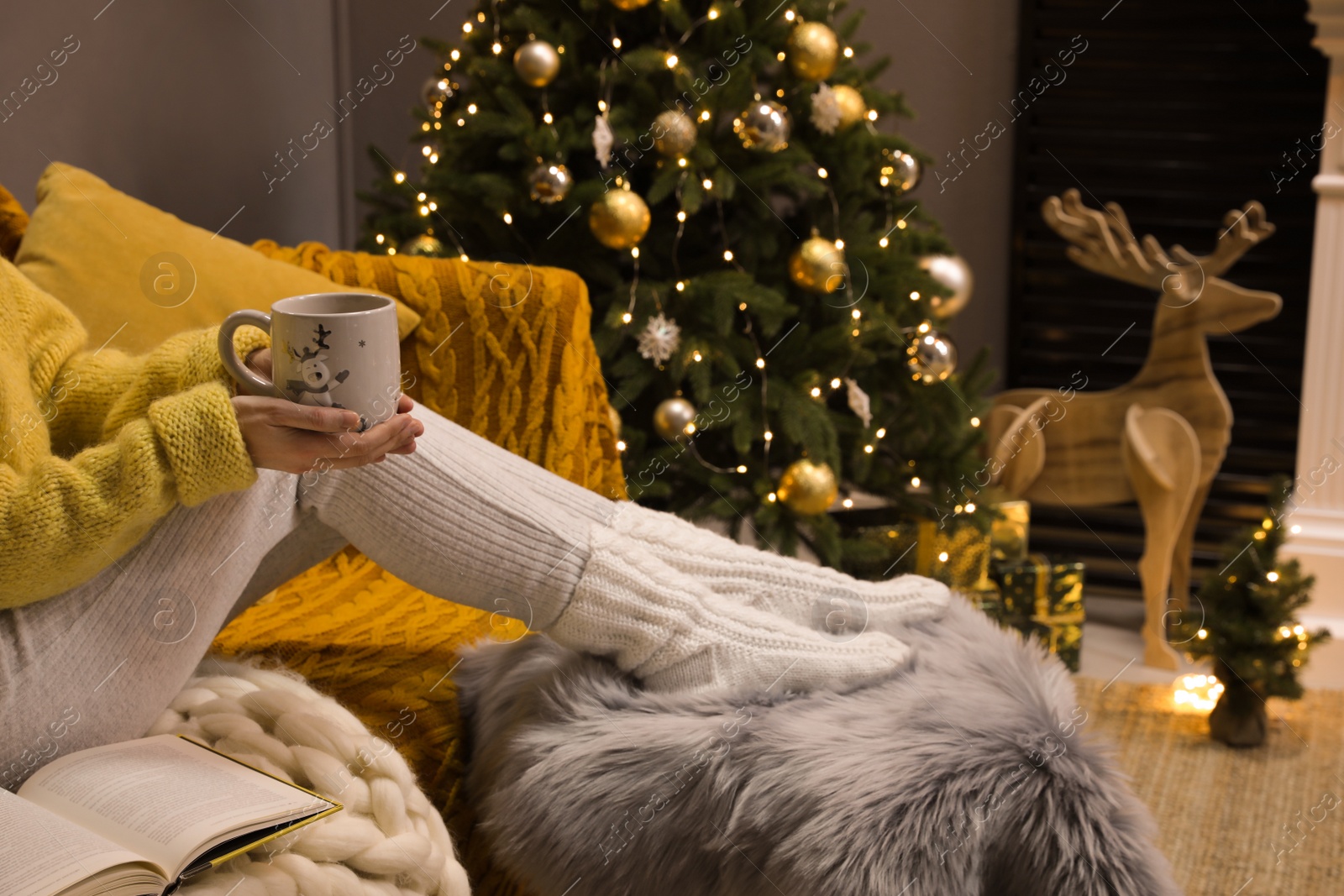 Photo of Woman with cup of drink sitting on sofa at home, closeup