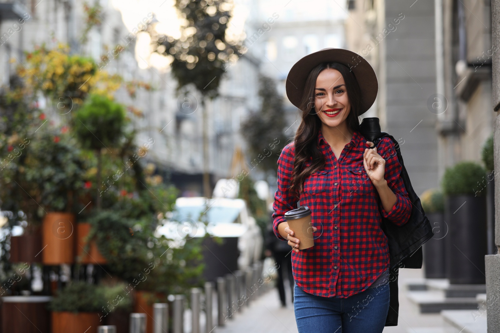 Photo of Beautiful woman walking along street on autumn day