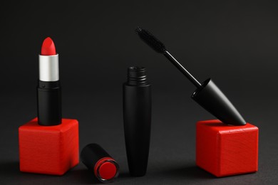 Photo of Beautiful lipstick and mascara on black background
