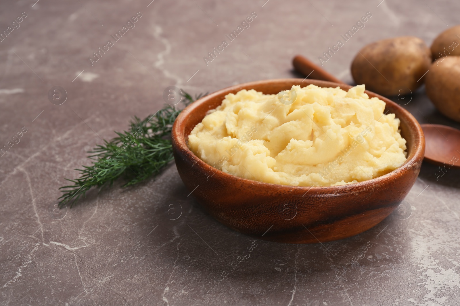 Photo of Bowl with mashed potatoes on grey table. Space for text