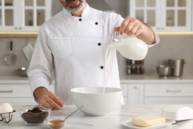 Professional chef making dough at white marble table indoors, closeup