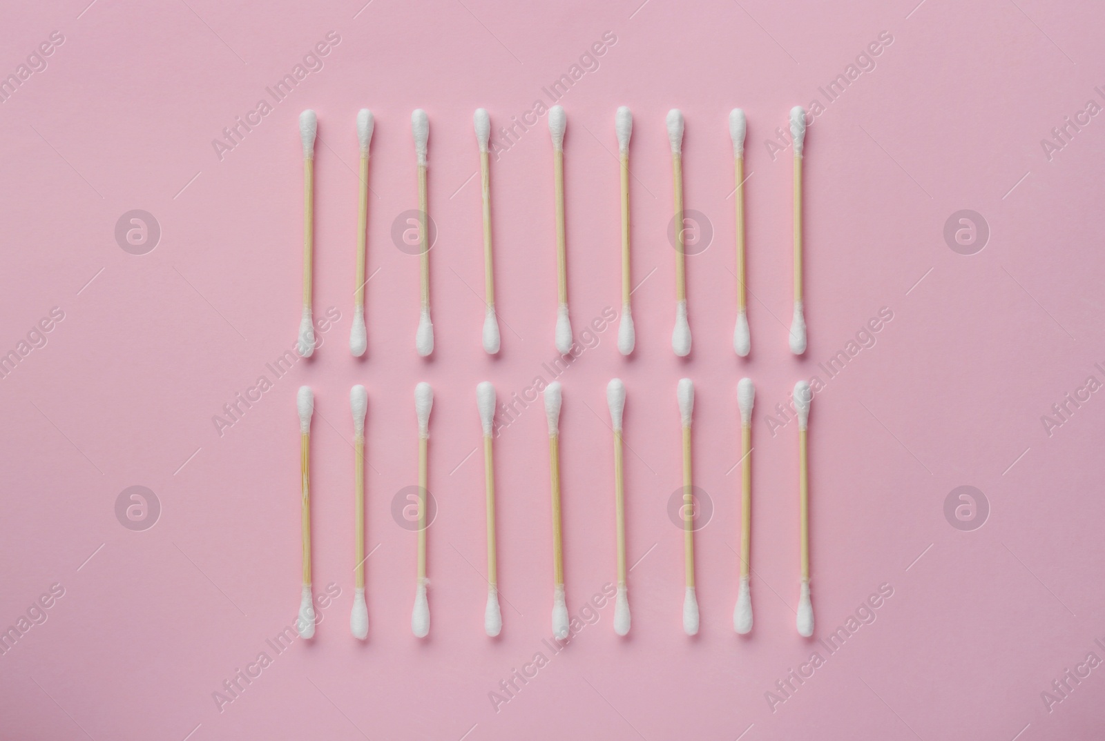 Photo of Many wooden cotton buds on pink background, flat lay