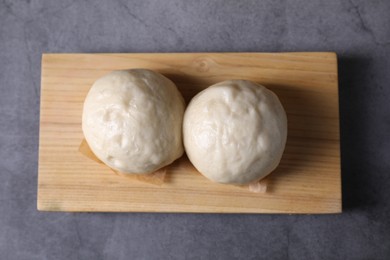 Delicious Chinese steamed buns on grey textured table, top view