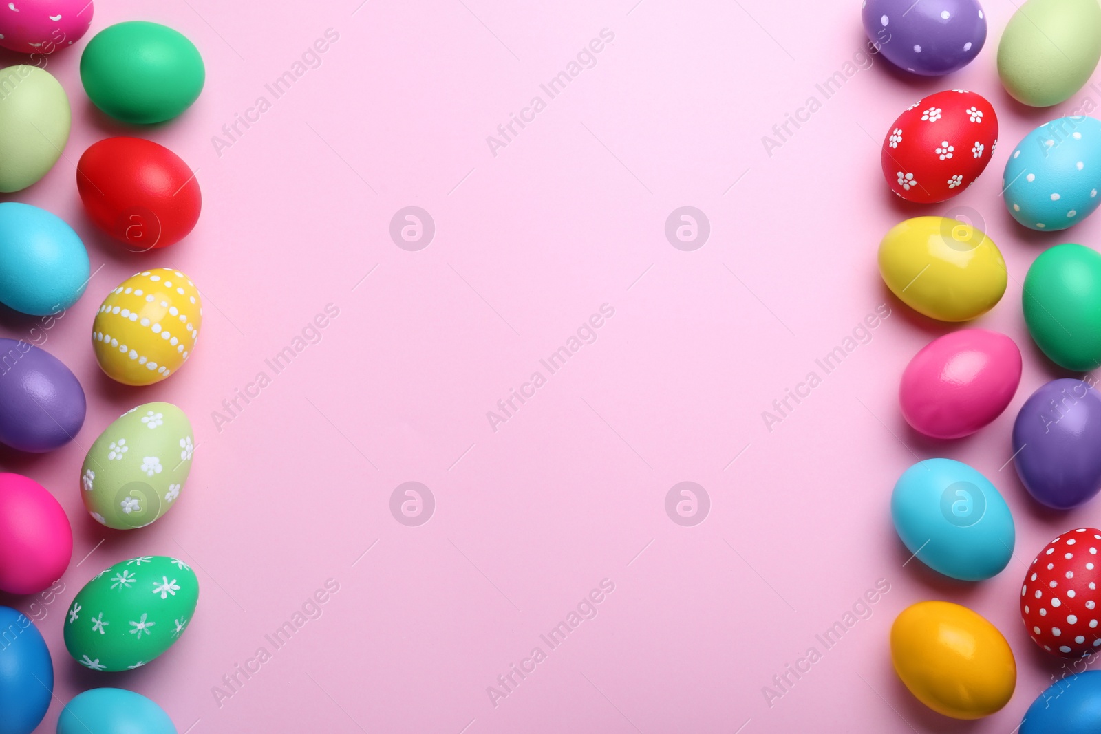 Photo of Bright painted eggs on pink background, flat lay with space for text. Happy Easter