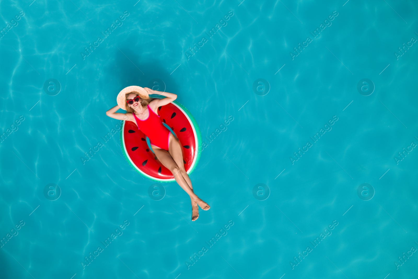 Image of Young happy woman with inflatable ring in swimming pool, top view. Summer vacation