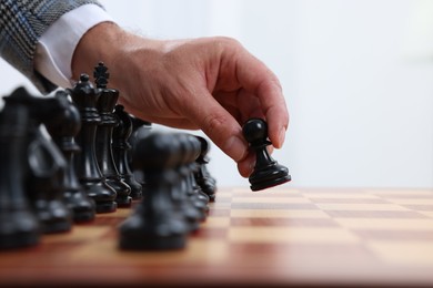 Photo of Man moving chess piece at checkerboard, closeup