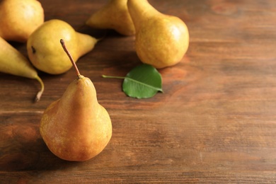 Ripe pears on wooden table. Space for text