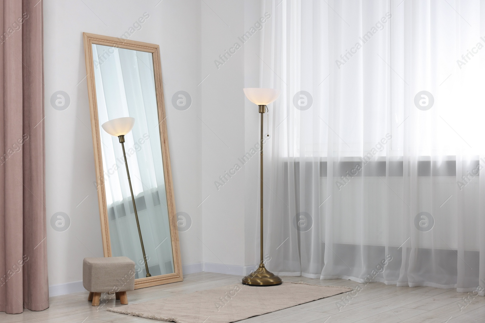 Photo of Stylish makeup room interior with long mirror and lamp