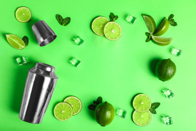 Photo of Flat lay composition with fresh juicy limes on light green background, space for text